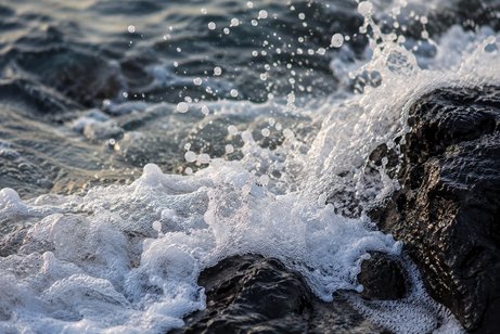 Original: sea foam breaking against rocks